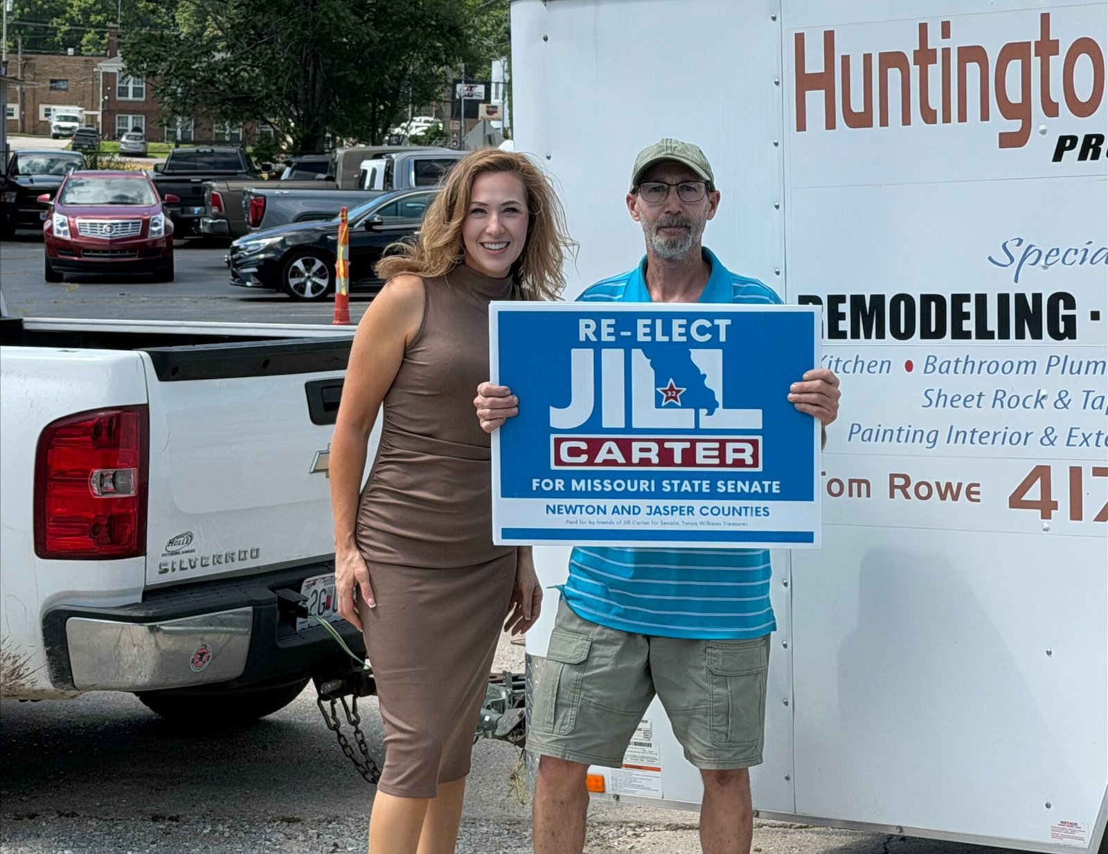 Two people stand outdoors holding a blue political campaign sign that reads 'RE-ELECT JILL CARTER FOR MISSOURI STATE SENATE.'