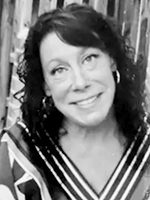 Smiling woman with dark hair in a striped V-neck top, grayscale photo.