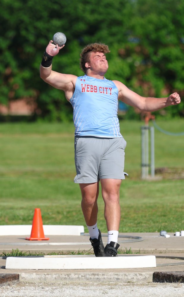 Athlete in a Webb City blue singlet mid-shot put on a throwing circle outdoors.